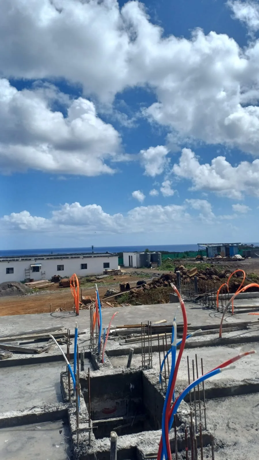 The completed ground-floor slab at Anna City with service conduits in place and the ocean on the horizon