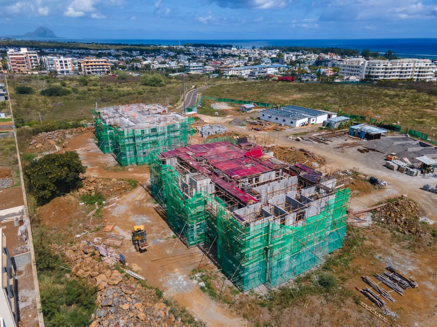 Oblique aerial view of the Anna City site with the second block’s top slab formwork in place and Le Morne on the horizon